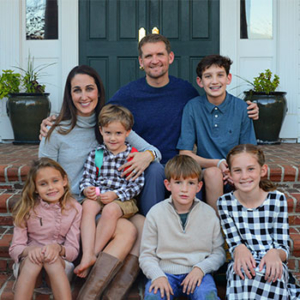 Issac Hartman with his wife and five kids sitting on a front porch