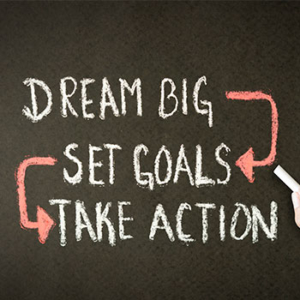 chalkboard with "dream big -> set goals -> take action" written in chalk