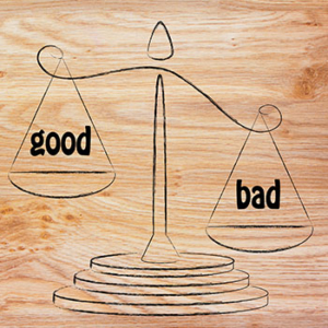 drawn scale on wooden background weighing 'good' versus 'bad'