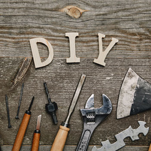Wooden table with wooden letters "DIY" and tools on the table