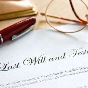 Top of a will document with glasses and a red pen on top of the last will