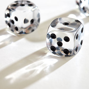 white table with two clear dice casting a shadow 