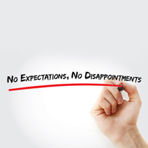 White board says, "No expectations. No disappointments" written in black. A hand is seen underlining the phrase with a red line.