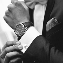 man in tuxedo wearing a nice watch (focus of the image is the watch)